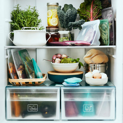 Interior de nevera con diferentes bolsas de silicona platino Stasher de diferentes tamaños y colores llenas de diferentes tipos de alimentos - LLevar & LLevar